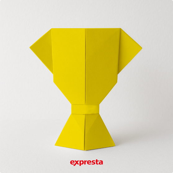 Gelber Origami-Pokal vor weißem Hintergrund mit expresta-Logo