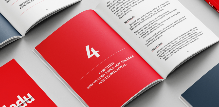 Otevřená kniha s červenou titulní stranou kapitoly položená mezi dalšími knihami na stole.